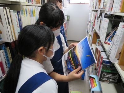 書庫1階で除籍する雑誌を手に取る様子